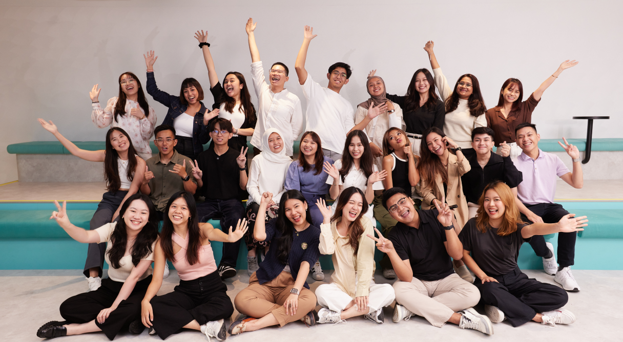 A group of students from the TikTok Shop Graduate Development program pose, wave and smile for a group photo.