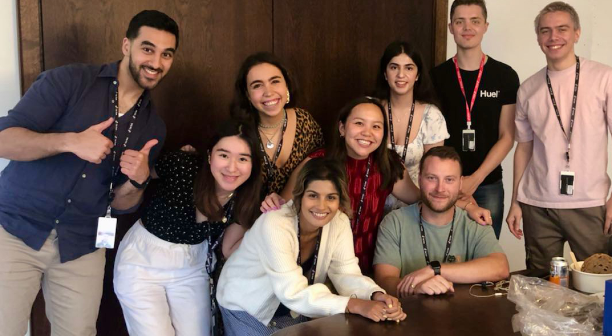 A group of TikTok Interns and Undergraduate students smile and give thumbs up as they pose for a picture together.