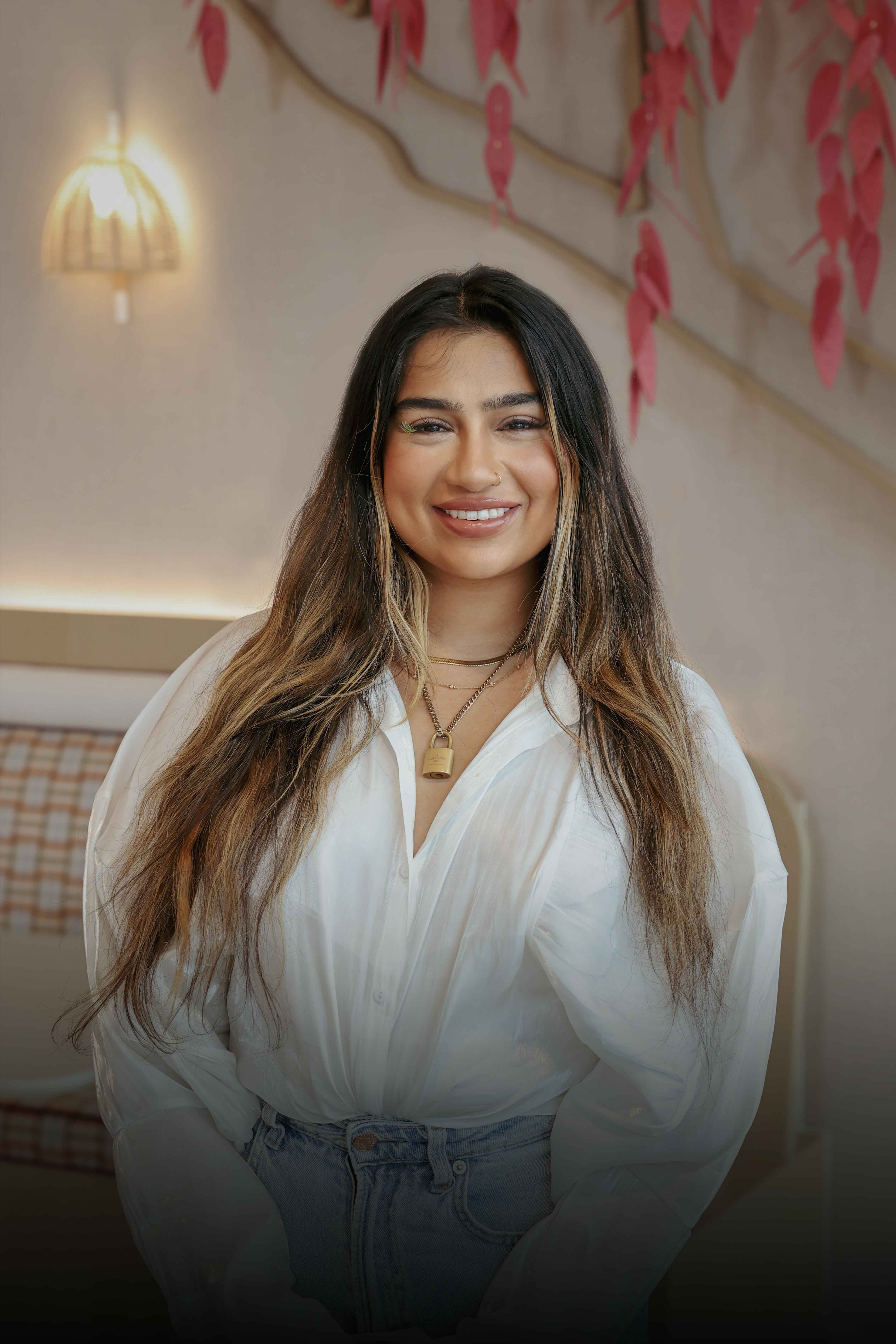 A young female TikTok employee with long blond hair smiles as she works on her laptop.