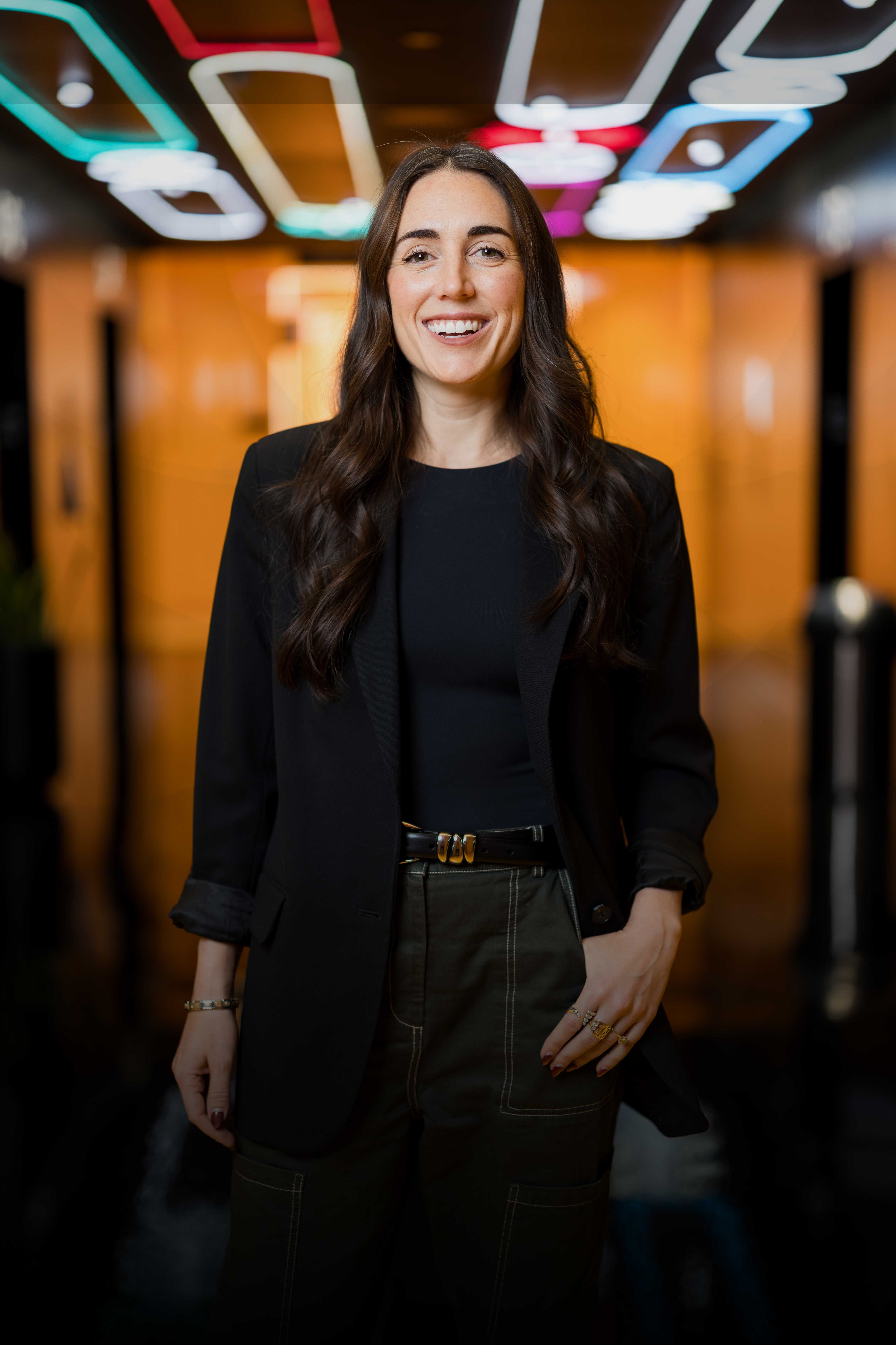 A young white male TikTok employee with a beard smiles and holds a smartphone.