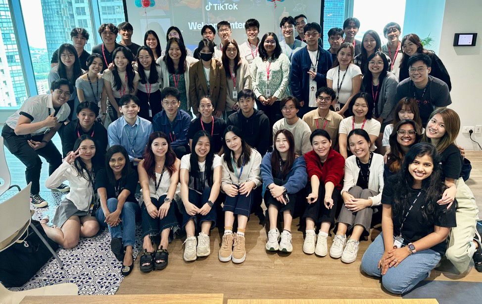 A group of TikTok Summer Interns pose excitedly for a group photo